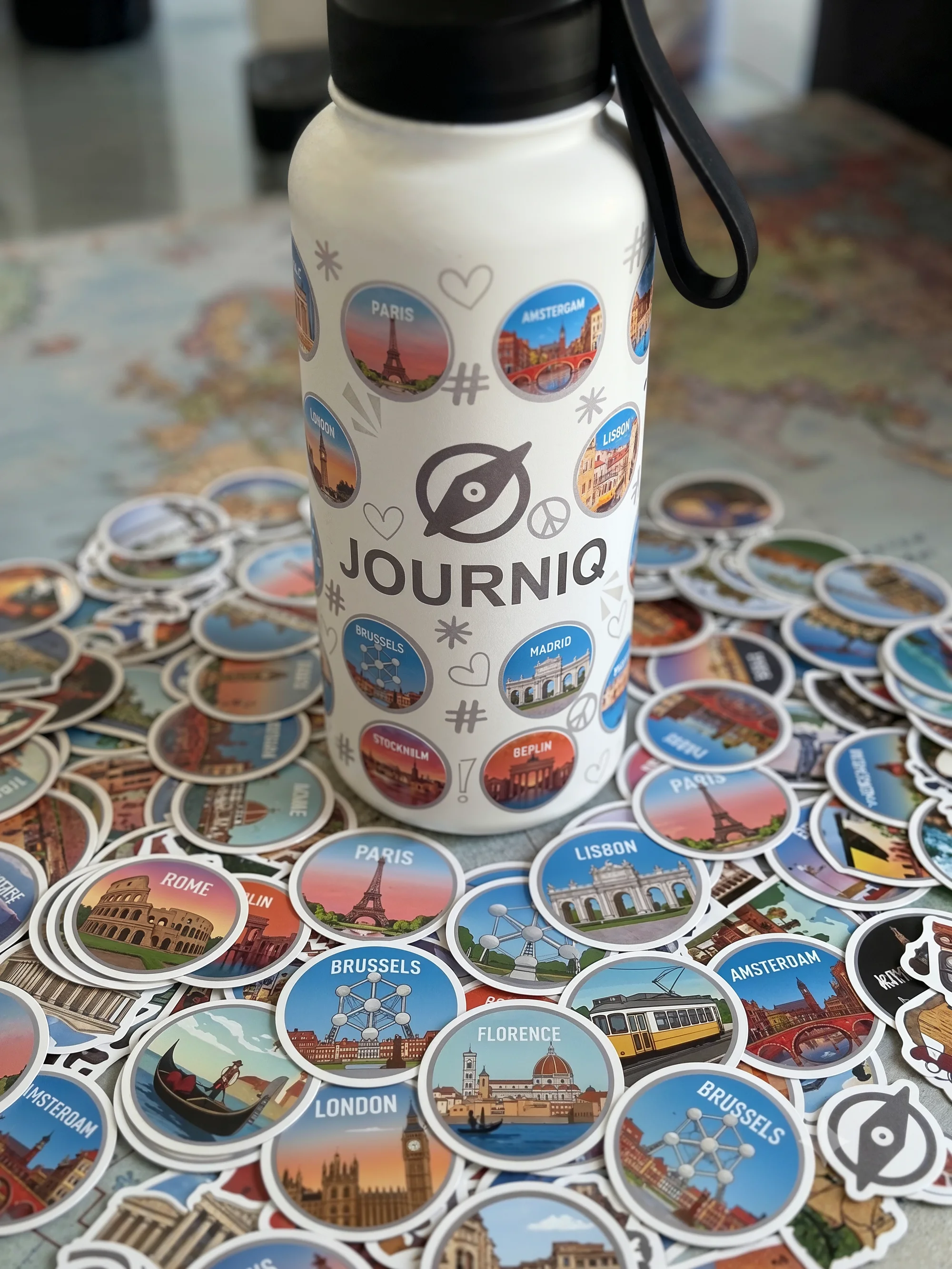 Botella JOURNIQ cubierta de stickers de destinos